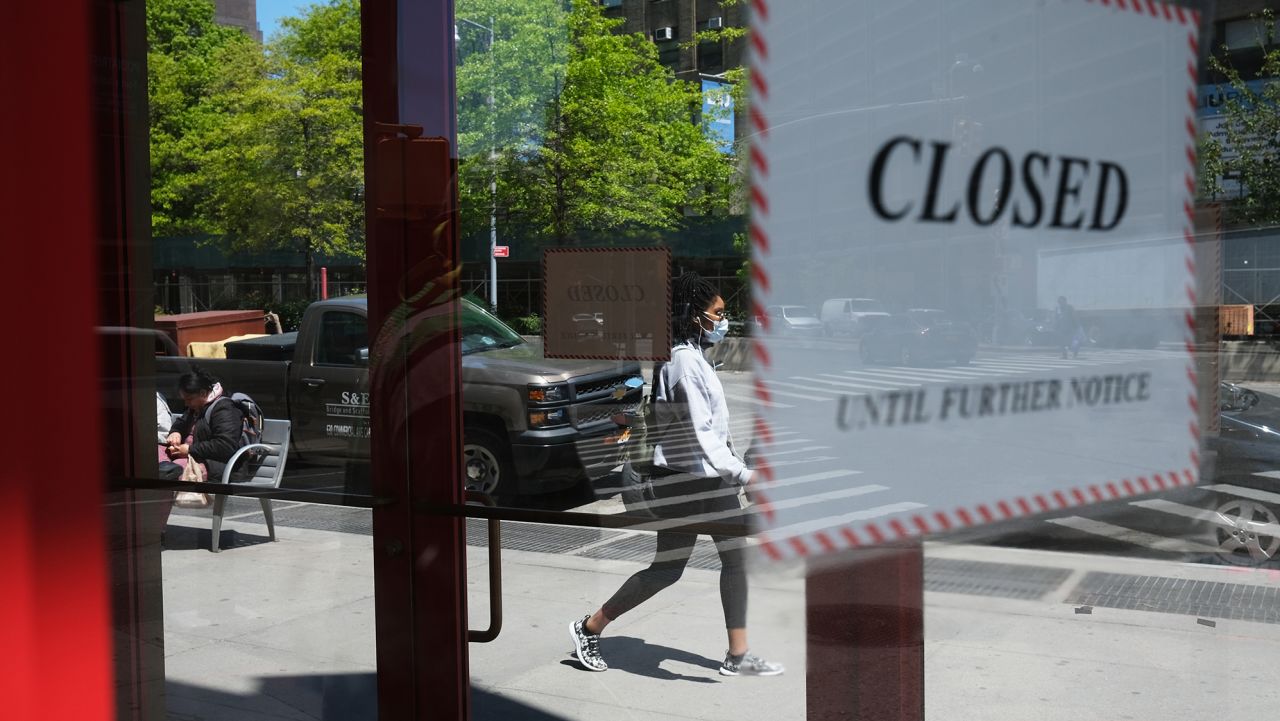 NEW YORK CITY- MAY 12: People walk through a shuttered business district in Brooklyn on May 12, 2020 in New York City. Across America, people are reeling from the loss of jobs and incomes as unemployment soars to historical levels following the COVID-19 outbreak. While some states are beginning to re-open slowly, many business are struggling to find a profit with the news restrictions and a population that is fearful of the contagious virus.  (Photo by Spencer Platt/Getty Images)