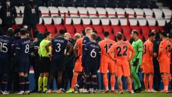 Romanian referee Ovidiu Hategan (in yellow) talks to Istanbul Basaksehir's staff members during the UEFA Champions League group H football match between Paris Saint-Germain (PSG) and Istanbul Basaksehir FK at the Parc des Princes stadium in Paris, on December 8, 2020. - Paris Saint-Germain's decisive Champions League game with Istanbul Basaksehir was suspended today in the first half as the players walked off amid allegations of racism by one of the match officials.
The row erupted after Basaksehir assistant coach Pierre Webo, the former Cameroon international, was shown a red card during a fierce row on the touchline with staff from the Turkish club appearing to accuse the Romanian fourth official of using a racist term. (Photo by FRANCK FIFE / AFP) (Photo by FRANCK FIFE/AFP via Getty Images)