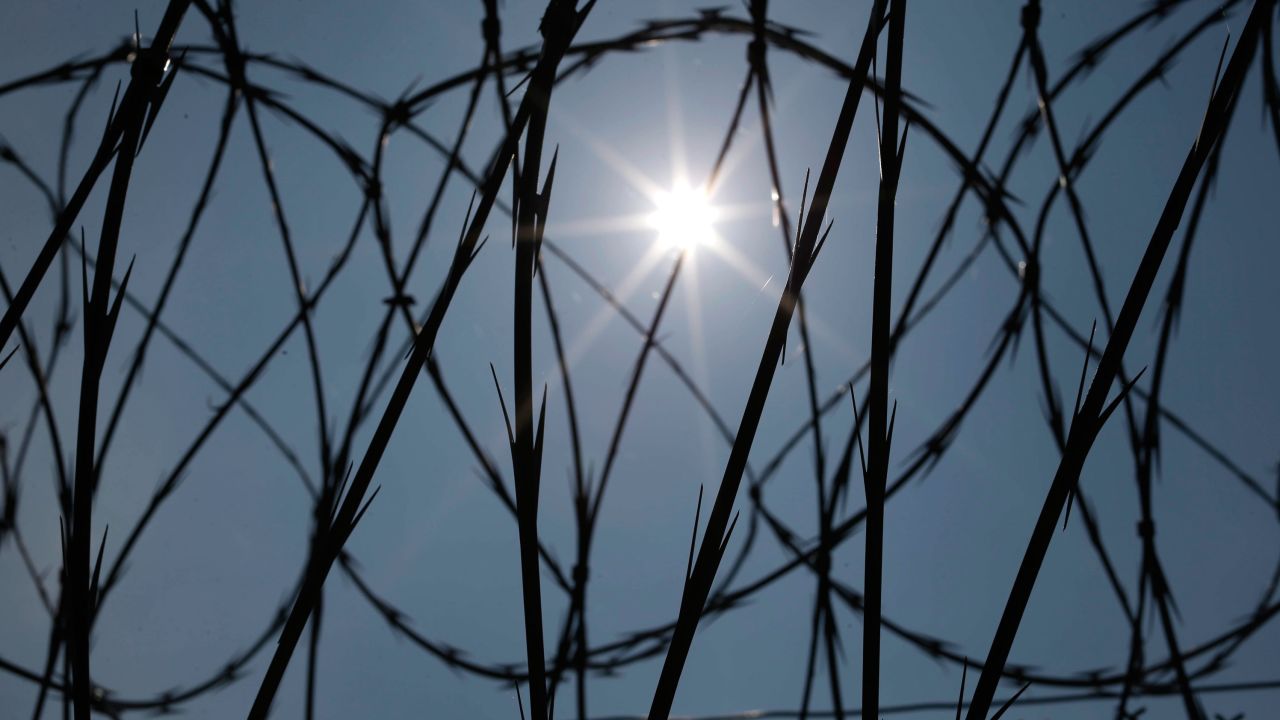 The sun shines through concertina wire on a fence at the Louisiana State Penitentiary in Angola, Louisiana, the largest maximum-security prison in the United States, named after the former plantation that occupied the area.