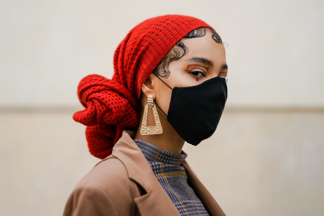 A Paris Fashion Week attendee wears bold eye makeup and a face mask at the Kenzo Spring-Summer show  on September 30, 2020.