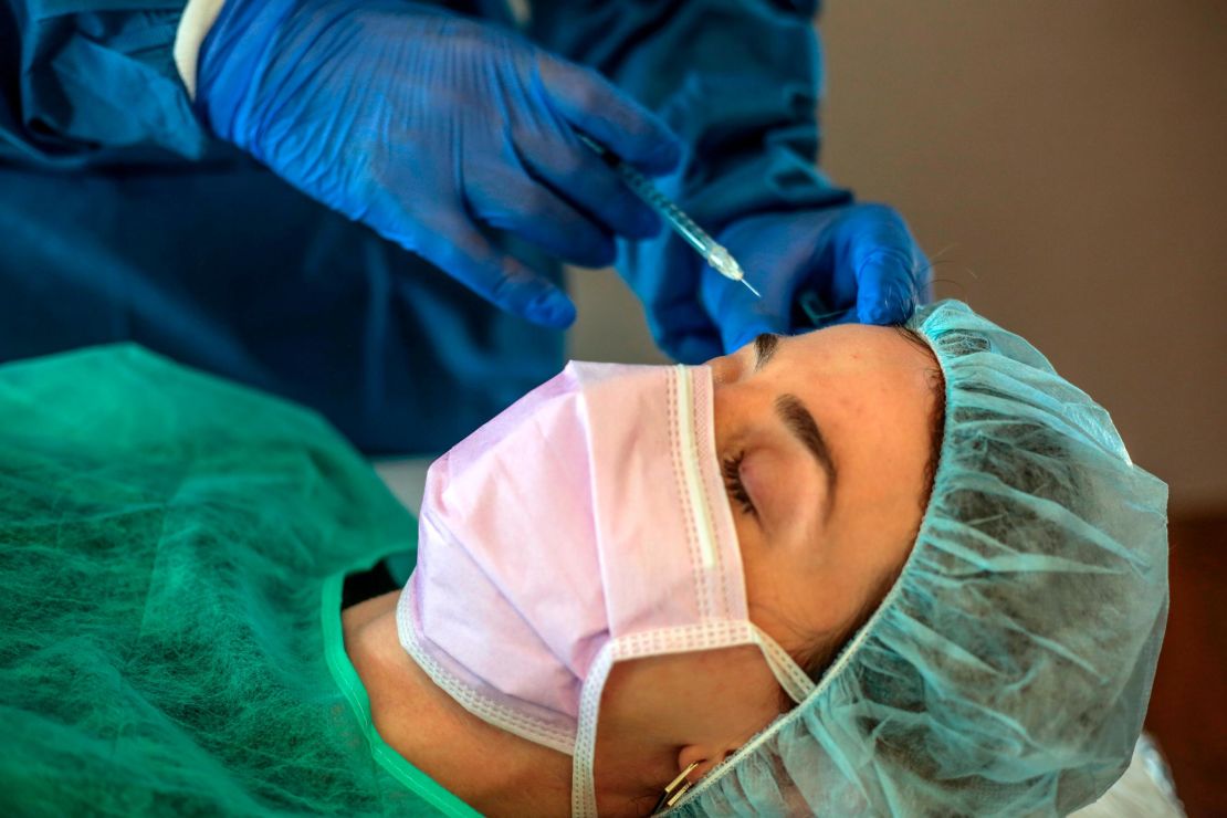 A patient receives Botox treatment while wearing PPE amid the Covid-19 pandemic during a clinical demonstration on May 11, 2020 in Sant Cugat, Spain.