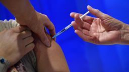 CARDIFF, WALES - DECEMBER 08: A woman receives an injection of the Pfizer-BioNTech Covid-19 vaccine at a health centre on the first day of the largest immunisation programme in the UK's history on December 8, 2020 in Cardiff, United Kingdom.  Wales joined the other UK nations in rolling out the covid-19 vaccine on Tuesday, a rare moment of coordination after months of disjointedness in the four nations' pandemic response. Wales introduced a 17-day "firebreak" lockdown in October and November to suppress the surge in covid-19 cases, but infections have continued to rise. (Photo by Justin Tallis - Pool / Getty Images)