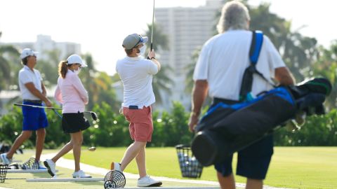 Players wearing face masks warm up on the range at the Miami Beach Golf Club on April 29, 2020 in Miami Beach, Florida.