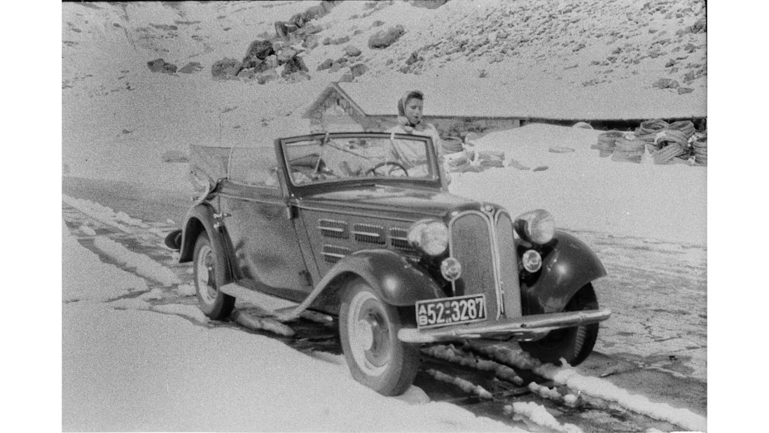 <strong>Vintage car:</strong> Also featured, a BMW convertible that dates from the mid-1930s, pictured navigating a snowy mountain pass. The photos seem to have been taken in Switzerland and Italy.