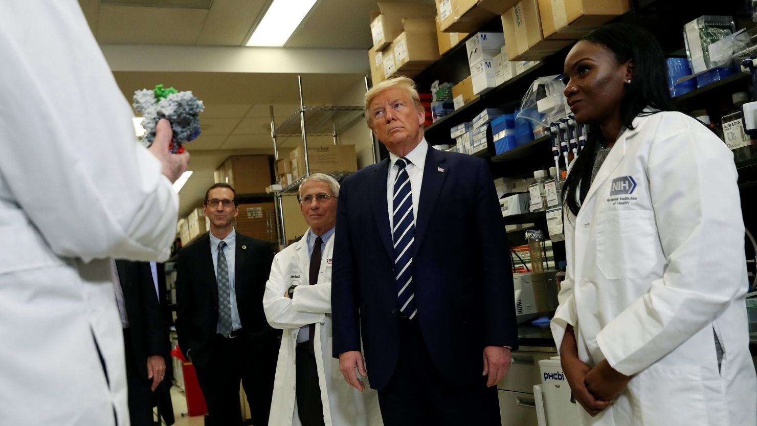 Drs. Anthony Fauci, left, and Kizzmekia Corbett, right, flank President Donald Trump at the NIH Vaccine Research Center in March.