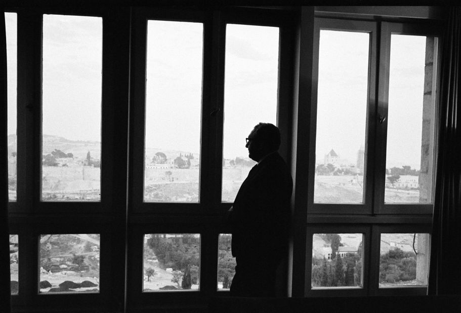 Kissinger looks out a window at the King David Hotel in Jerusalem in 1975.