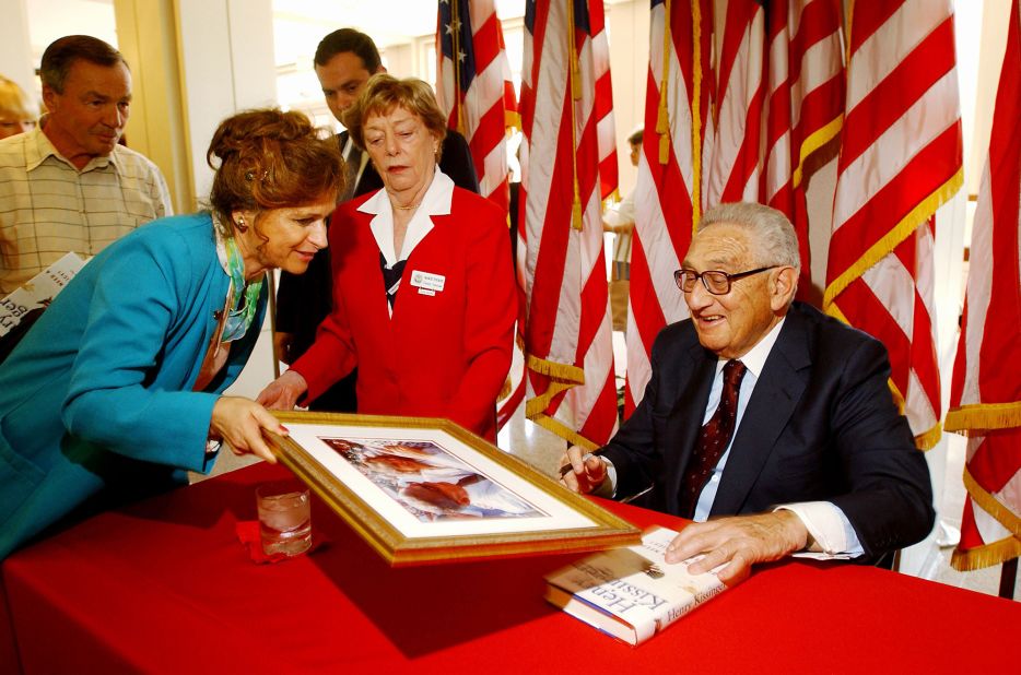 Kissinger signs a picture of himself at the Richard Nixon Library in Yorba Linda, California, in 2001.