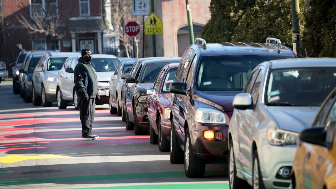 Cars line up as food boxes are passed out to people in need outside of St. Sabina's Catholic church on December 03, 2020 in Chicago, Illinois. The church has held the weekly food distribution since the start of the pandemic. According to Fr. Michael Pfleger the need now is the greatest he has seen during his nearly 40 years at the church.    (Photo by Scott Olson/Getty Images)