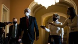 Senate Majority Leader Mitch McConnell, a Republican from Kentucky, center, wears a protective mask while walking to the Senate floor at the U.S. Capitol on Monday, December 7, 2020. 