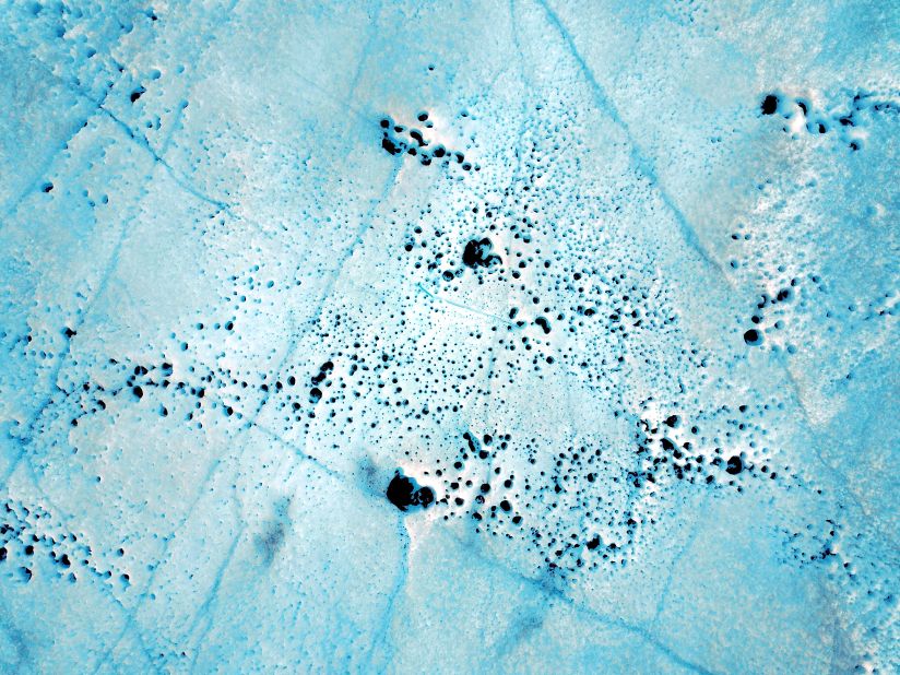 Greenland's ice sheet is also under threat from other microscopic lifeforms that thrive on the surface of the ice. One type of bacteria causes sediment to form, creating what's known as cryoconite holes on the surface of the ice. The largest holes in this image are approximately 20 inches in diameter. 
