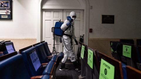 A member of the White House cleaning staff sprays a disinfectant in the James Brady Press Briefing room in Washington in October 2020.