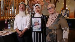 Marhaba Yakub Salay (centre) holds a framed photograph of her sister, Mayila Yakufu, who was sent sent to detention centre in Xinjiang.