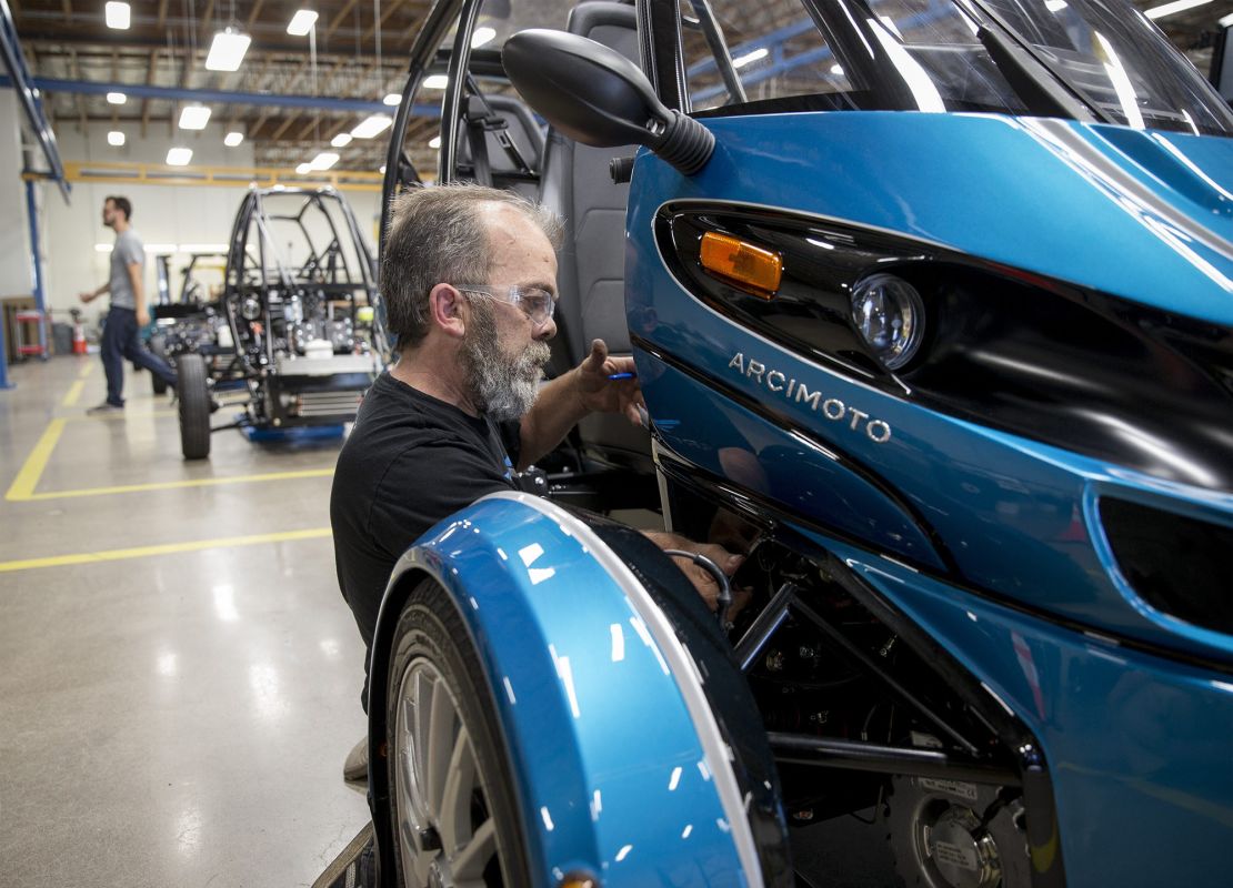 Mike Dunphy installs lower dash panels on an Arcimoto vehicle.