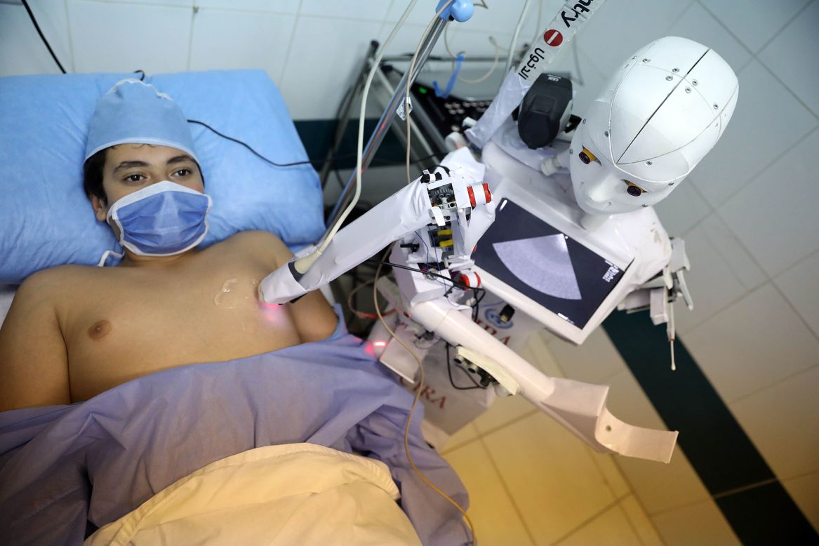 A Cira-03 robot performs an echocardiogram on a hospital volunteer in Tanta, Egypt, on Thursday, December 3. The robot, which is still being trialed, was also designed to test for Covid-19.