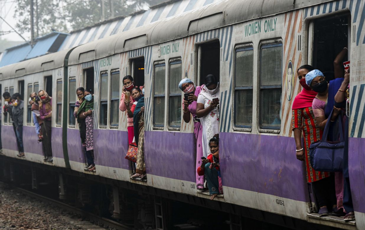 Commuters look out at protesters blocking a train track in Kolkata, India, on Tuesday, December 8. Thousands of Indian farmers have been protesting new agricultural laws that they say could destroy their livelihoods.
