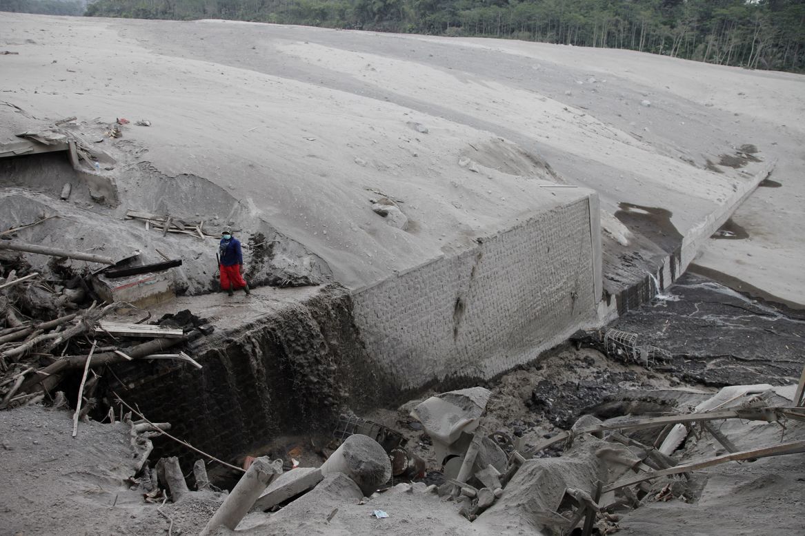 Workers with the Indonesian National Disaster Management Agency, assisted by villagers, try to evacuate trucks and excavators on Thursday, December 3, after Mount Semeru erupted, burying the vehicles in volcanic materials.