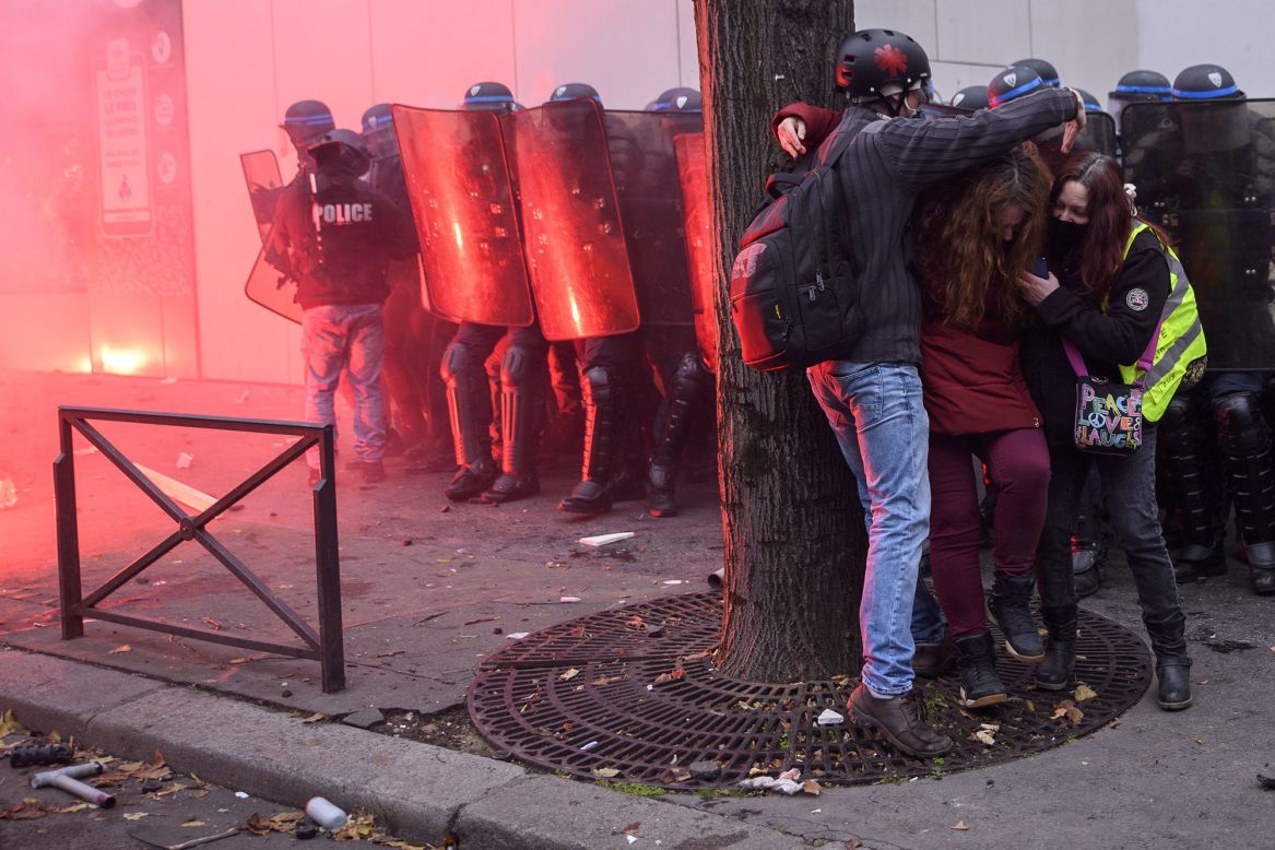 People take cover as police clash with protesters in Paris on Saturday, December 5. <a href="https://www.cnn.com/2020/11/28/europe/france-protests-security-law-intl/index.html" target="_blank">Demonstrations have been taking place across France</a> as people voice their opposition to a proposed security law and its signature measure to restrict the filming of police officers.
