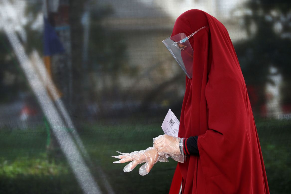 A woman wears a face shield and protective gloves while voting in regional elections in Tangerang, Indonesia, on Wednesday, December 9.