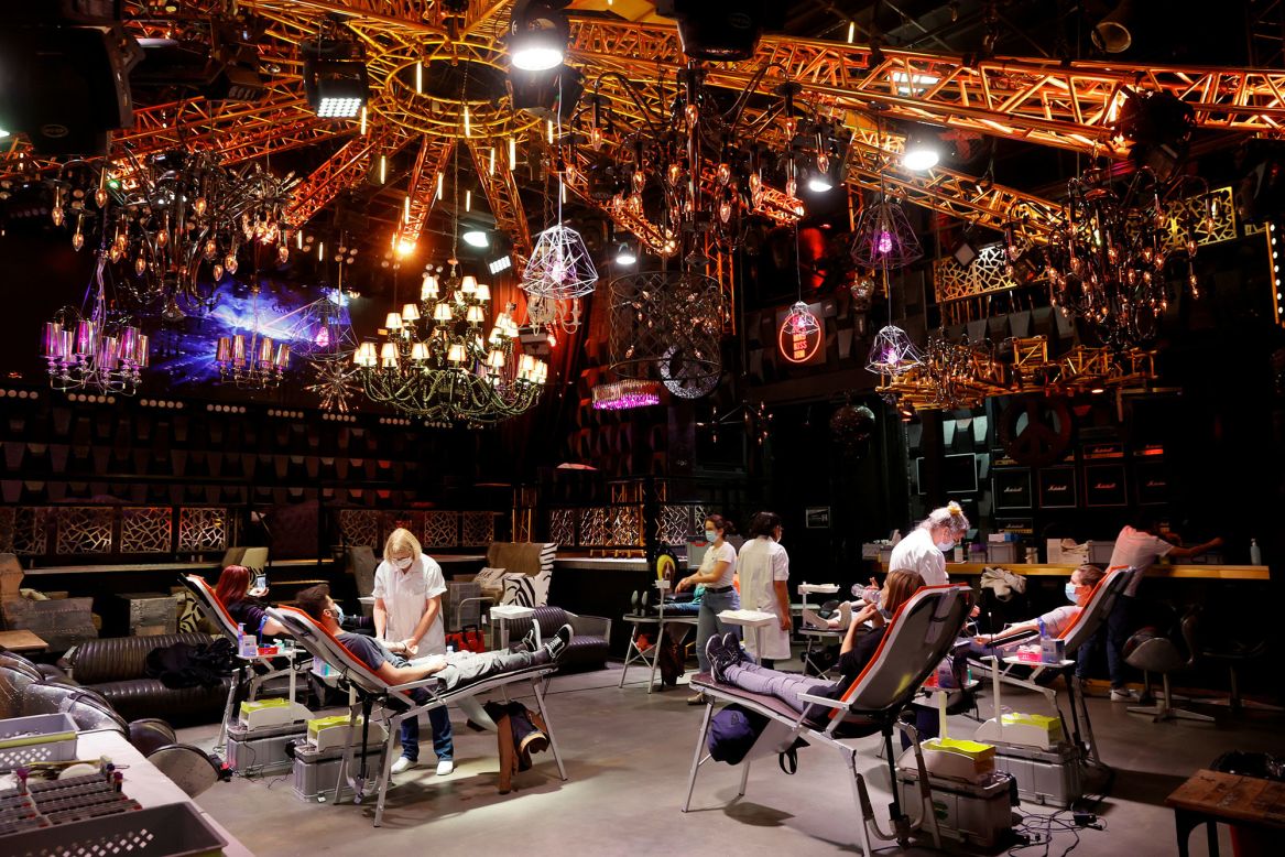 People give blood on the stage of a closed nightclub in Lausanne, Switzerland, on Monday, December 7.