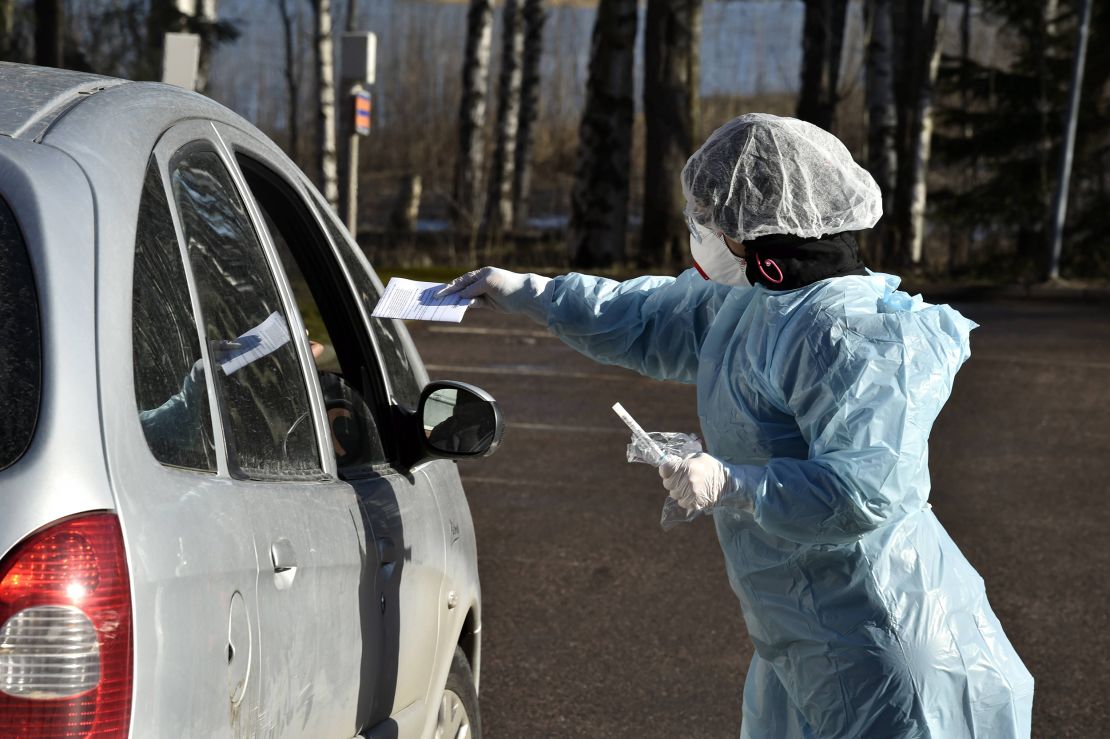 Medical workers take samples from patients at a coronavirus drive-in test center in Espoo, Finland, on April 1, 2020. (Jussi Nukari/Lehtikuva/AFP)