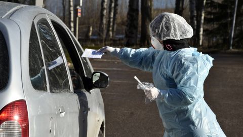 Medical workers take samples from patients at a coronavirus drive-in test center in Espoo, Finland, on April 1, 2020. (Jussi Nukari/Lehtikuva/AFP)