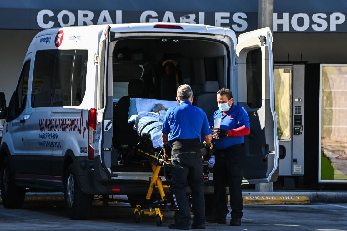Medics earlier this month transfer a patient on a stretcher from an ambulance outside of emergency at Coral Gables Hospital where coronavirus patients are treated near Miami.