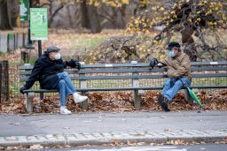 Americans will still need to mask up even with the US vaccine rollout underway. Shown are two men talking while wearing masks in Central Park December 2 in New York.