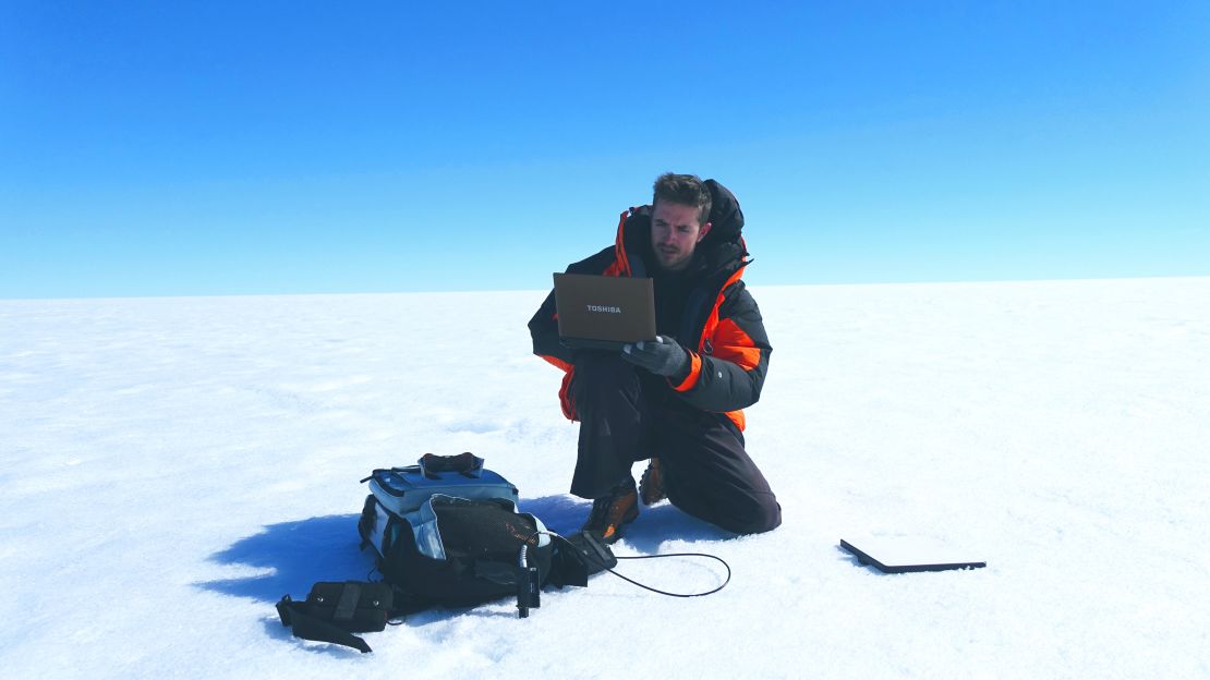 British glaciologist Joseph Cook preparing equipment to test the "albedo" or reflectivity of Greenland's ice sheet.