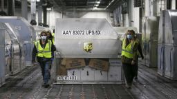 UPS employees move one of two shipping containers containing the first shipments of the Pfizer and BioNTech COVID-19 vaccine  inside a sorting facility at UPS Worldport on December 13, 2020 in Louisville, Kentucky. (Photo by Michael Clevenger - Pool/Getty Images)