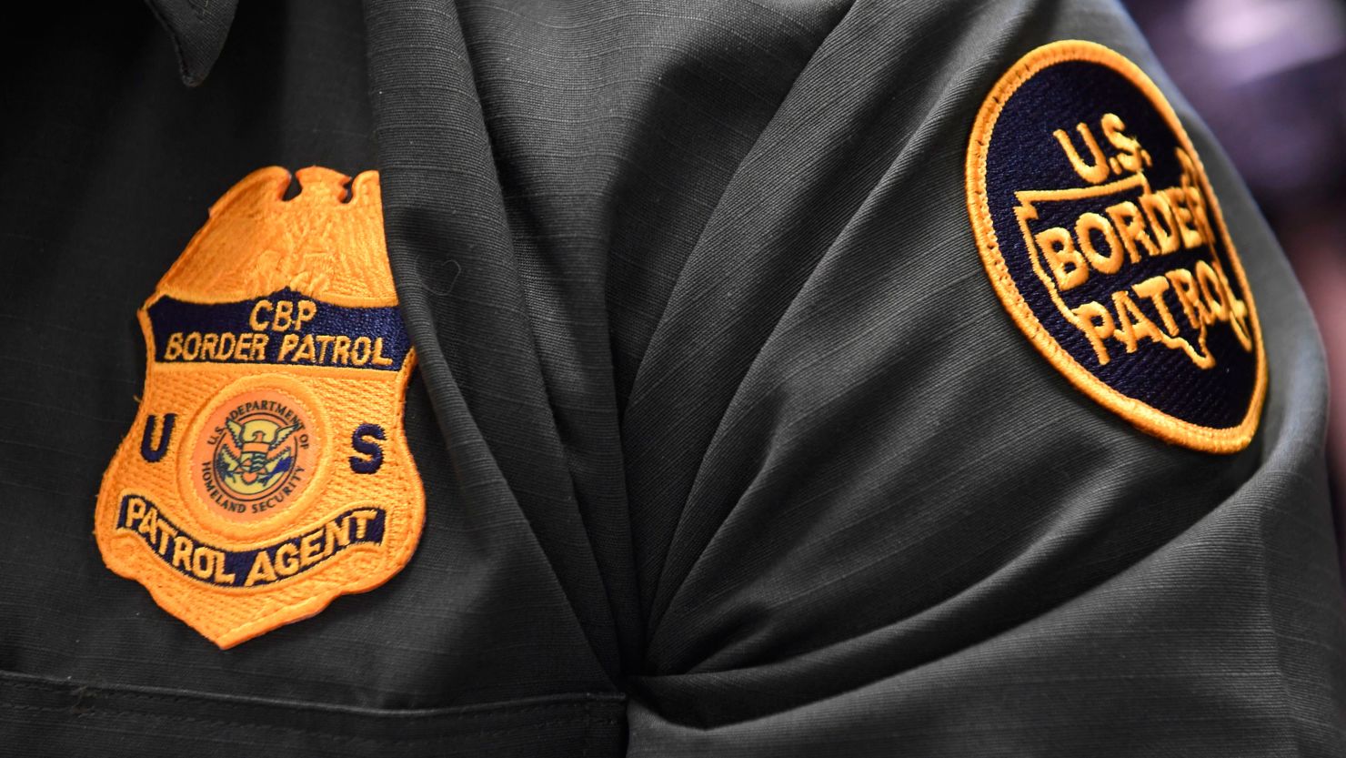 A US Customs and Border Protection agent sitting at a ceremony in 2019.