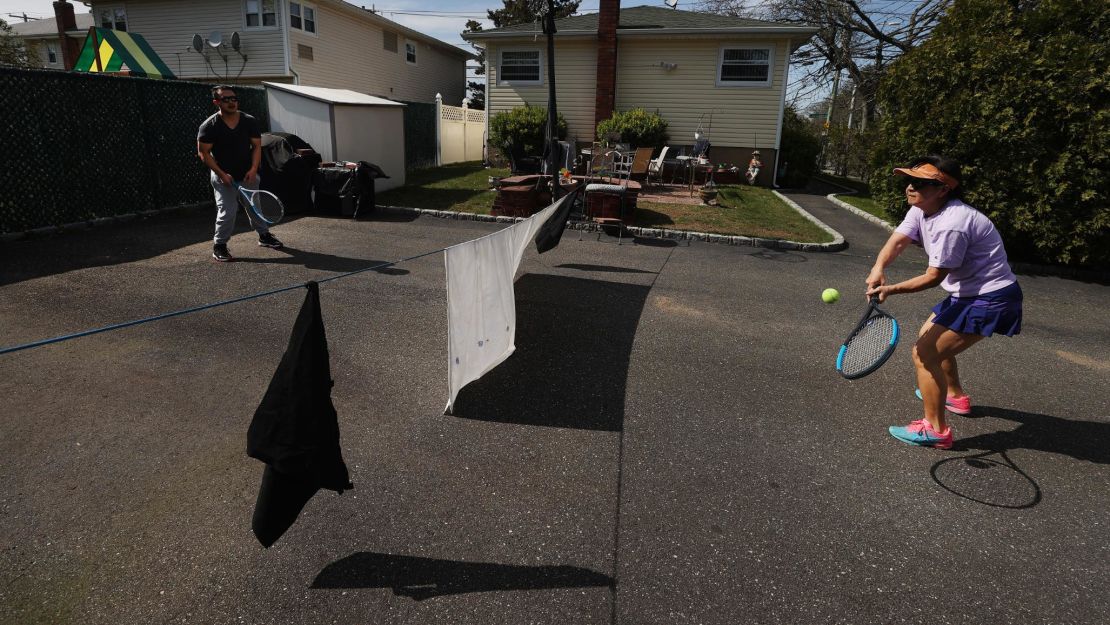 With facilities closed due to the Covid-19 pandemic, Ana Diaz (right), a nurse at Northwell Syosset Hospital, plays tennis with her son Mel Diaz, who also works at the hospital as a patient transporter, at their home on a makeshift court April 25 in Merrick, New York. 