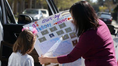Christine Groff (right) shows the map for a drive-by scavenger hunt to her daughter Aria (left) on her sixth birthday in Alameda, California, April 1. Aria and her family drove to the homes of 16 friends with each providing the clue for their next stop on the hunt.