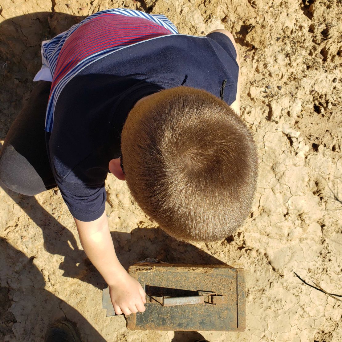 Dan DeJager's older son Hunter, 8, investigates a geocache the family found recently.