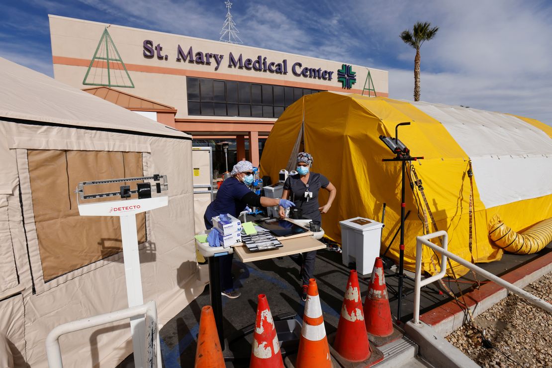 Emergency room tech Brenda de la Cruz and registered nurse Janet Hays work December 8 outside St. Mary Medical Center in Apple Valley, California. The triage tents handle the overflow of patients.