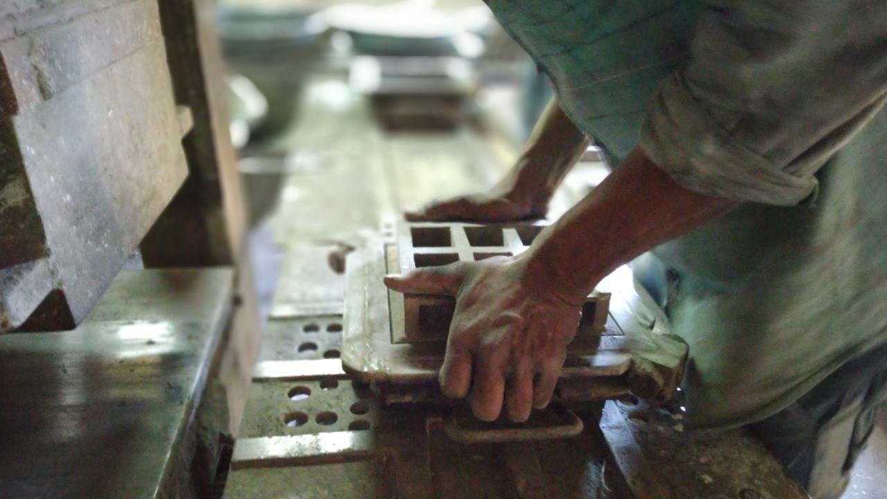 Carbon Craft Design uses a hydraulic press to mold  carbon, marble and cement into a monochromatic tile.
