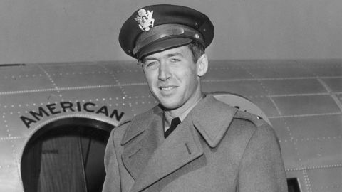 Stewart in the early 1940s with his Air Force cap in front of a military plane.