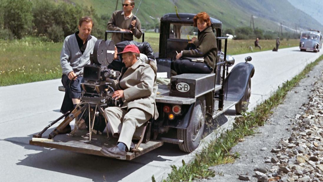 Director Guy Hamilton (left) with other production staff on a tracking car, used to record driving footage.
