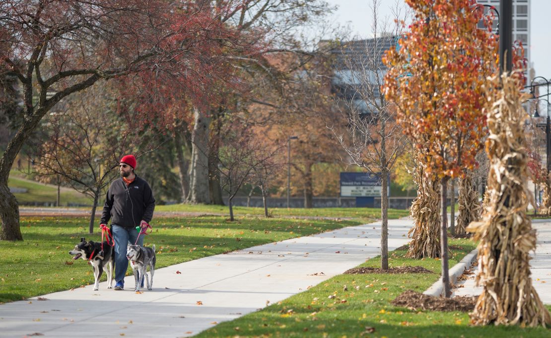 South Bend resident Alec Hipshear walks his two dogs on the newly widened sidewalk along Jefferson Street in South Bend, Indiana. (2014 photo)