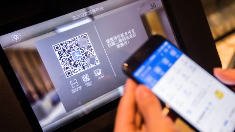 A Chinese man uses an "electronic ID card" in a mobile payment app to check into a hotel in Hangzhou in April 2017. The blurred QR code was not added by CNN.