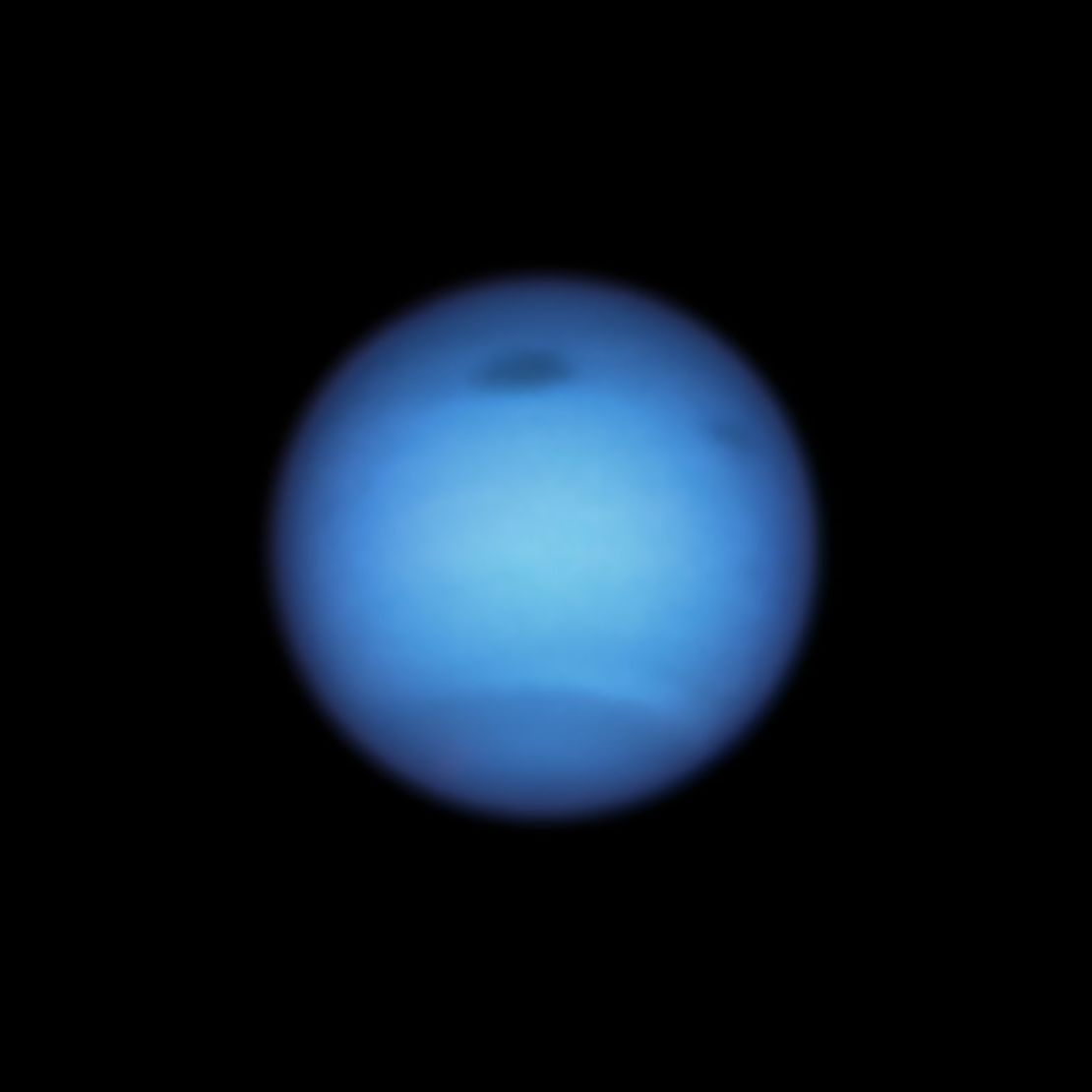 This Hubble Space Telescope snapshot of Neptune reveals a massive dark storm (top center) and the emergence of a smaller dark spot nearby (top right). 