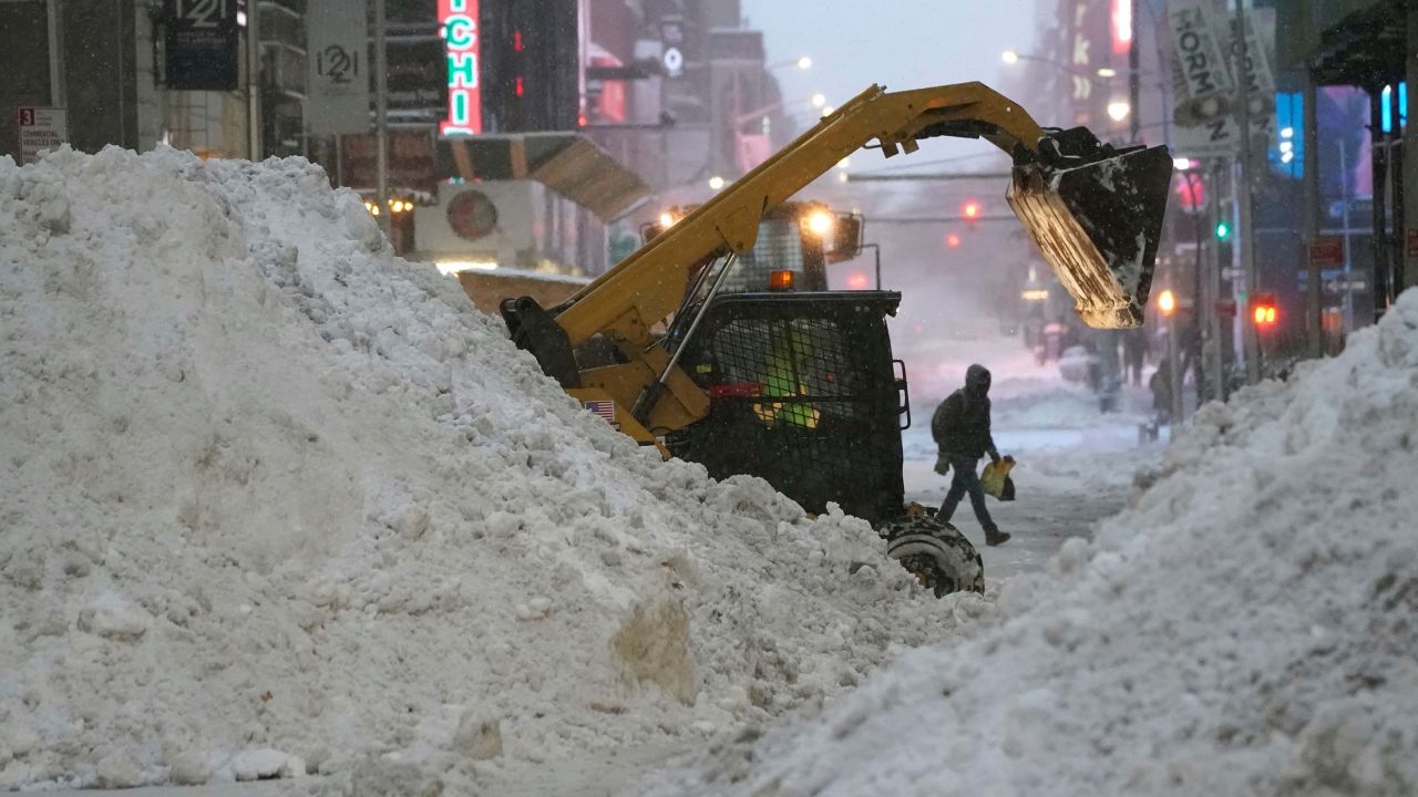 A snowplow pushes snow near Times Square Thursday in New York.
