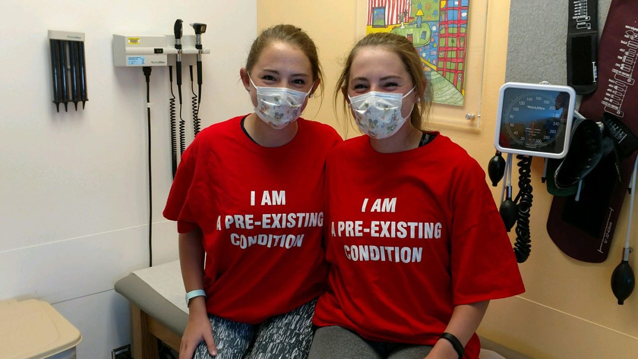 Andrea and her twin sister, Alyson (left), during a clinic appointment in 2017.