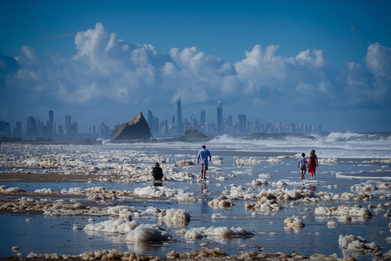 Foam is scattered on Currumbin Beach on Tuesday, December 15, after parts of Australia were hit with heavy rain and strong winds.