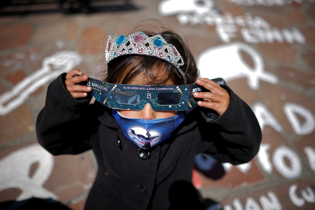 A girl puts on protective glasses to watch the solar eclipse in Bariloche, Argentina, on Monday, December 14.