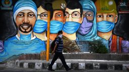 TOPSHOT - A man walks past a mural of frontline workers after the government eased a nationwide lockdown imposed as a preventive measure against the COVID-19 coronavirus in New Delhi on July 14, 2020. (Photo by Sajjad  HUSSAIN / AFP) (Photo by SAJJAD  HUSSAIN/AFP via Getty Images)