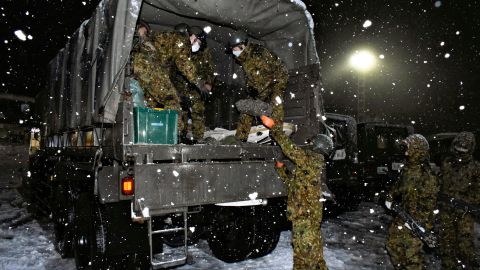 Japan Self-Defense Forces personnel prepare food and water for people stuck on Kanetsu expressway on December 17.