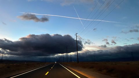 Jet trails streak the sky over the Mojave Desert at night.