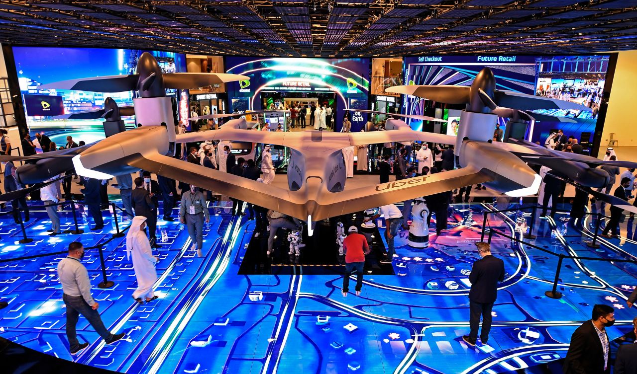 Visitors stand next a concept flying car at the Dubai World Trade center. GITEX was held from December 6 to December 10. (Photo by KARIM SAHIB/AFP via Getty Images)