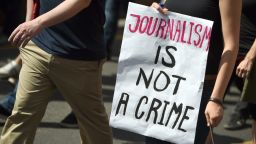 FILES - Protester holds a poster written "Journalism in not a crime" during a demonstration in support of freedom of press on August 1, 2015, in Berlin as reaction to treason investigation against two writers of the news blog Netzpolitik. A clash between Germany's chief prosecutor and justice minister broke into the open on August 4, 2015, sparked by a treason probe against a blog that had published domestic security documents. The case centres of the blog Netzpolitik.org (Net politics), which earlier his year published documents on plans by Germany's domestic security agency to step up Internet surveillance.  AFP PHOTO / DPA / BRITTA PEDERSEN +++ GERMANY OUT        (Photo credit should read BRITTA PEDERSEN/DPA/AFP via Getty Images)