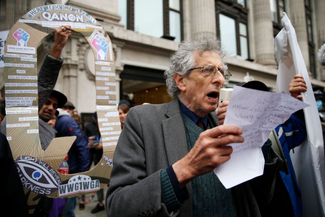 Piers Corbyn speaks to demonstrators as a man holds up a QAnon sign behind him during a StandUpX protest in London this October.
